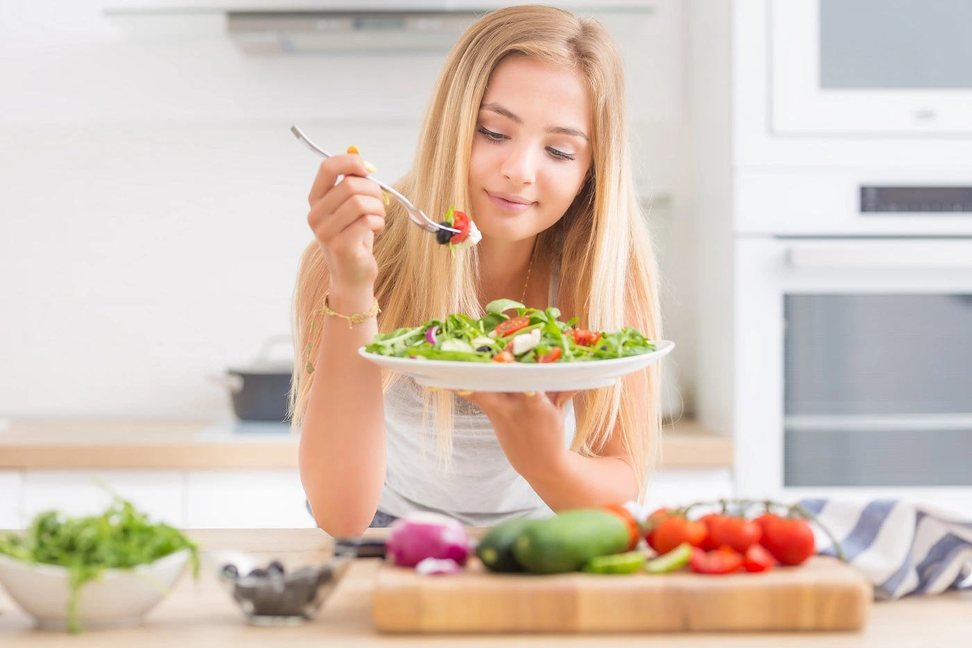 Woman eating green foods in the kitchen