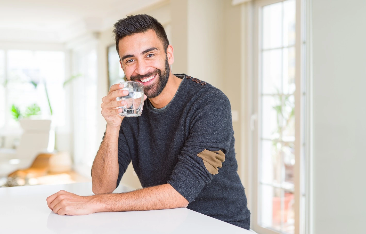 Man in his 40s drinking a glass of water