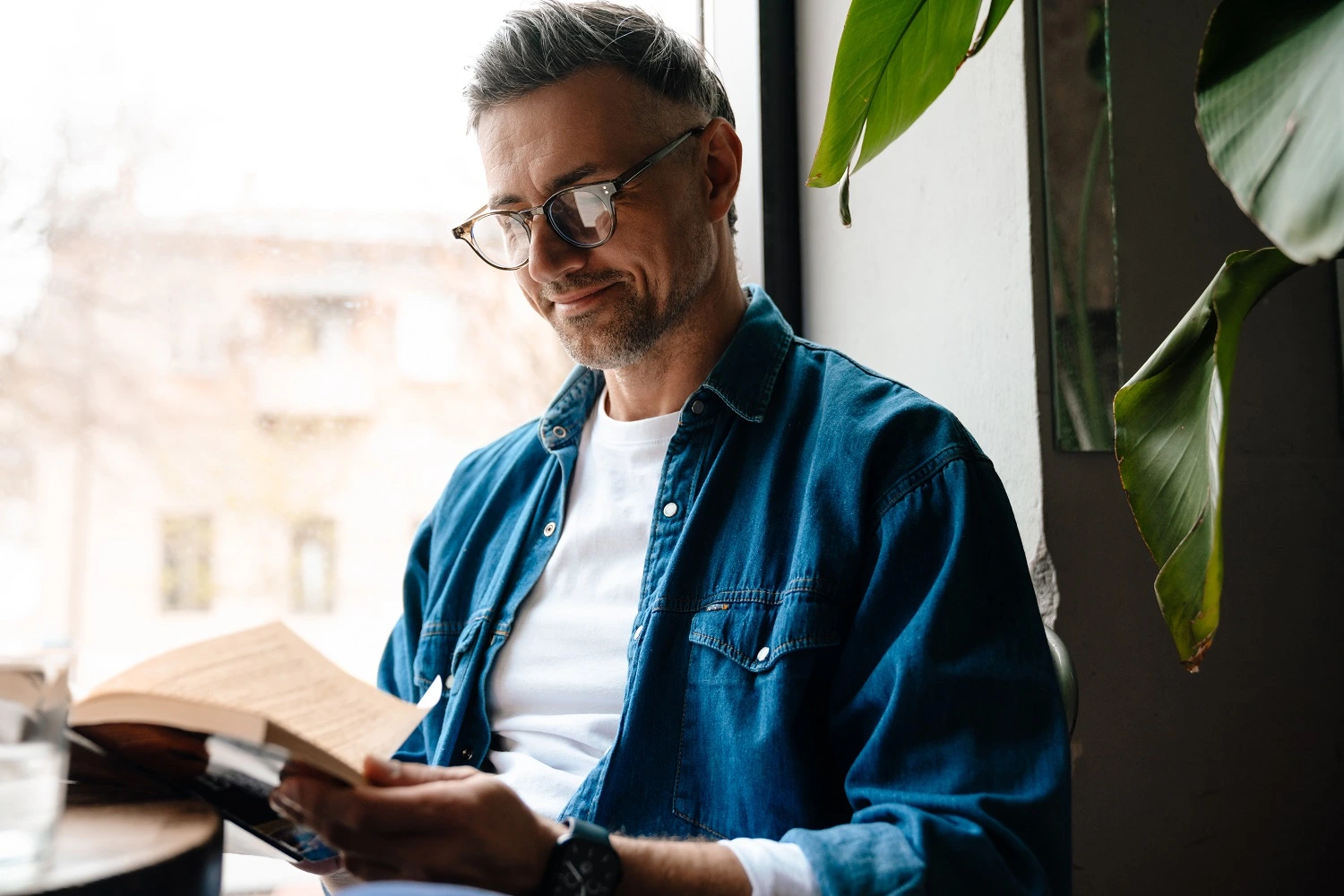 Man smiling while he is reading a book