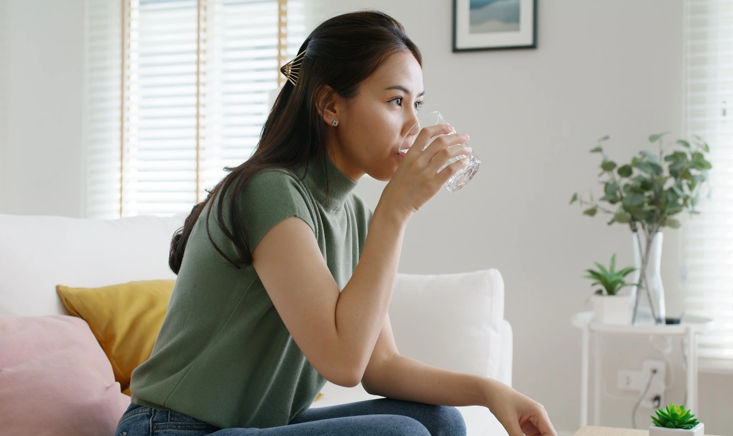 Person taking supplements with water as part of a daily routine