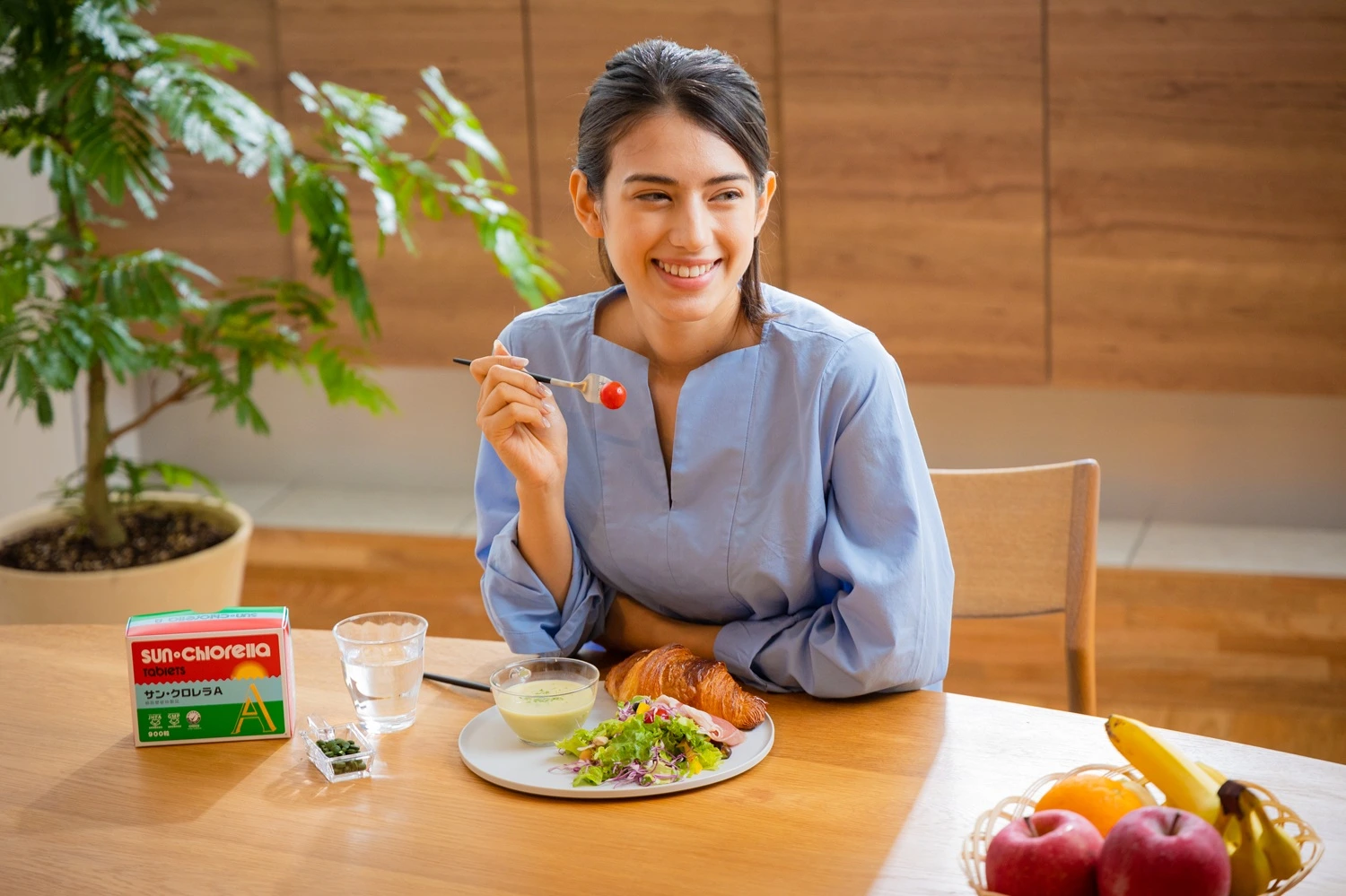 Woman eating breakfast with chlorella at the table
