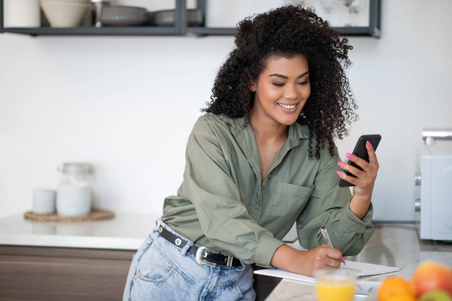 Woman taking notes about diet in kitchen