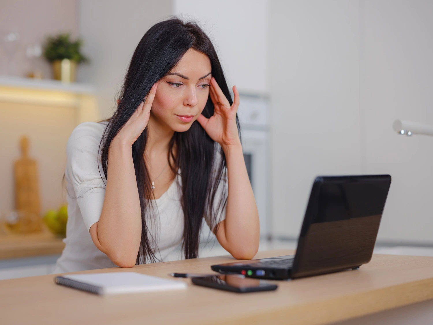 woman experiencing difficulty concentrating while working on a laptop, illustrating brain fog and mental clarity challenges