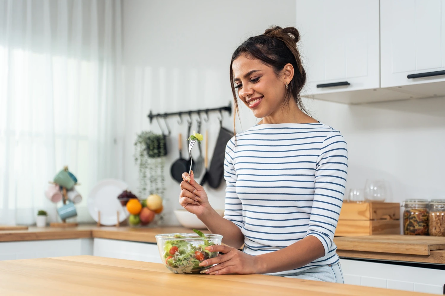 Woman eating a vegetarian food in the kitchen
